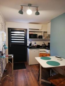 uma cozinha com uma mesa branca e uma porta preta em Le 26 em Ruffec