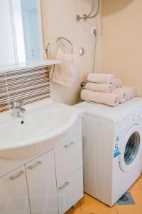 a bathroom with a washing machine and a sink at Apartman PETRA in Trogir