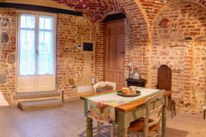 a room with a table and a brick wall at appartamento mamasita in Andezeno