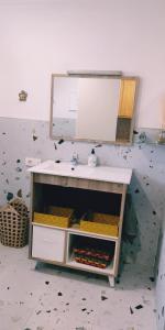 W łazience znajduje się umywalka i lustro. w obiekcie apartamentos Vv casafaromar w mieście Morro del Jable