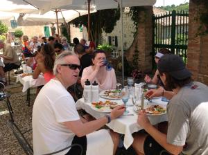 a group of people sitting at a table eating food at La Romita Ospitalità Rurale Familiare in Montisi