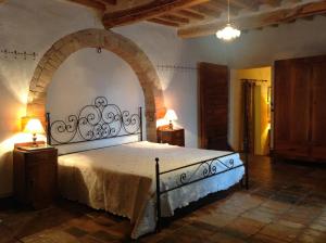 ein Schlafzimmer mit einem großen Bett mit einem Torbogen in der Unterkunft La Romita Ospitalità Rurale Familiare in Montisi