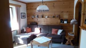 ein Wohnzimmer mit einem Sofa und einem Tisch in der Unterkunft Ferienwohnungen Kirmse in Inzell