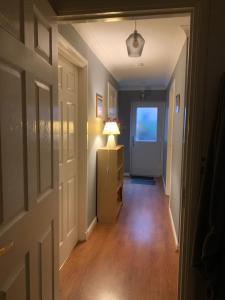 a hallway with a door and a lamp on a dresser at Brada View Bamburgh in Bamburgh