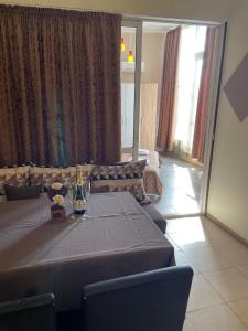 ein Esszimmer mit einem Tisch und einer Flasche Wein in der Unterkunft Diva Apartments & Diva restaurant BBQ&pool bar in Warna