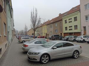 a row of cars parked on a city street at Štolcova room in Komárov