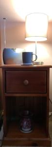 a table with a lamp and a bowl on it at Brada View Bamburgh in Bamburgh