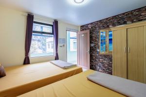 um quarto com 2 camas e uma janela em Victor Charlie Hostel em Ilha de Cát Bà