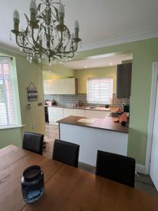 a kitchen with a dining table and a chandelier at Wishbone House in Bridlington