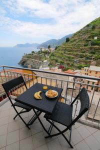 stół i krzesła z talerzem jedzenia na balkonie w obiekcie Casa Vacanze Da Paulin w mieście Manarola