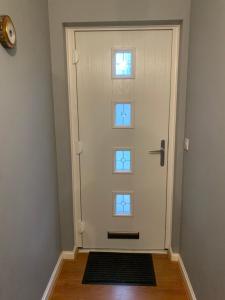 uma porta branca com duas janelas num corredor em Brada View Bamburgh em Bamburgh