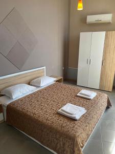 um quarto com uma cama com duas toalhas em Diva Apartments & Diva restaurant BBQ&pool bar em Varna