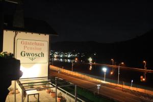 Ferienwohnung Moselpension Gwosch في بروتيج-فانكيل: علامة على جانب المبنى في الليل