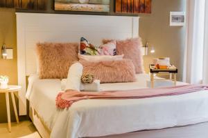 a bedroom with a bed with a pillow and a cat laying on it at Mariù Upmarket Accommodation in Nelspruit