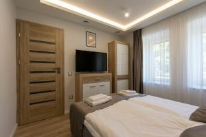 A bed or beds in a room at PontJó Apartman Miskolc