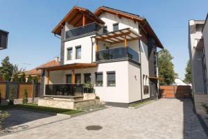 Biały dom z brązowym dachem w obiekcie PontJó Apartman Miskolc w Miszkolcu