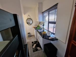 Baño pequeño con lavabo y espejo en Casa-Pel Tiny House, en Palapye