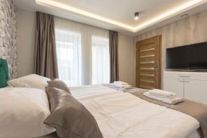 A bed or beds in a room at PontJó Apartman Miskolc