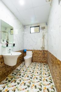 ein Bad mit einem Waschbecken und einem WC in der Unterkunft Victor Charlie Hostel in Cát Bà