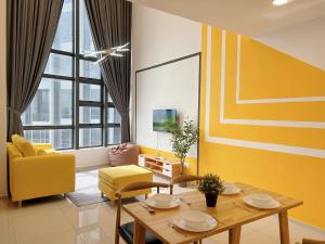 a living room with a wooden table and yellow chairs at EkoCheras Designer Suite by Moka @ Cheras in Kuala Lumpur