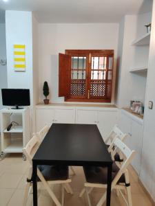 une salle à manger avec une table et des chaises noires dans l'établissement Centro Sevilla, El Arenal, à Séville