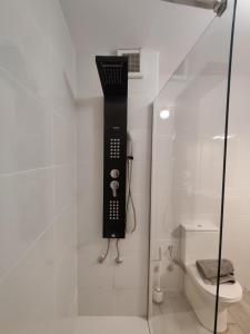 - une salle de bains avec un téléphone noir sur le mur à côté des toilettes dans l'établissement Centro Sevilla, El Arenal, à Séville