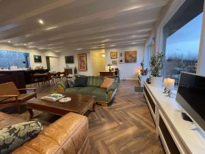 a living room with a couch and a tv at Enchanting country home in Laugaras