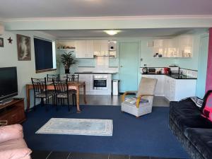 een woonkamer en een keuken met een tafel en stoelen bij Spacious Unit by the Beach in Sunny Blackmans Bay in Kingston Beach