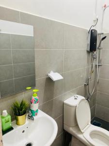 een badkamer met een toilet, een wastafel en een spiegel bij Homestay Alor Setar Nearby Hospital Sultanah Bahiyah in Alor Setar