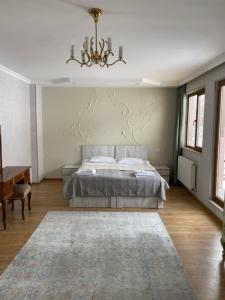 um quarto com uma cama e um lustre em ART HOUSE 33 em Kutaisi
