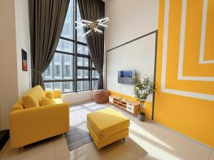 sala de estar con sofá amarillo y TV en EkoCheras Suite by MOKA en Kuala Lumpur