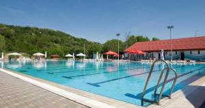 a large swimming pool with chairs and umbrellas at Cabin In The Woods Vukelic in Stubicke Toplice