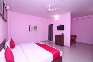 a bedroom with a white bed with red pillows at CORBETT SUNRISE RESORT in Rāmnagar