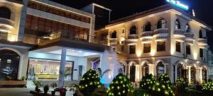 a hotel with christmas trees in front of a building at The Kannelite (Hotel Sakchi Vihar By JTDC) in Jamshedpur