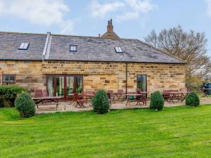 an old stone house with picnic tables in a yard at Seaton Court - Uk31955 in Staithes