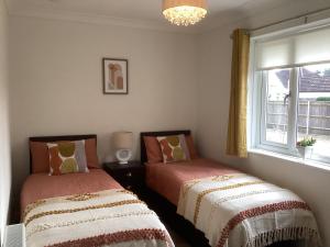 two beds in a room with a window at Forest Heath Holidays - Denphyl in Ringwood