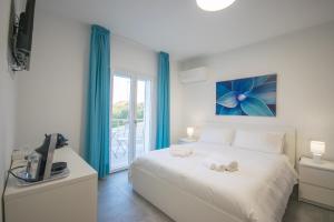 een slaapkamer met een wit bed en een raam bij Artemisia Home in Olbia