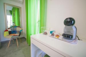 eine Küche mit einem Mixer auf einer Theke mit grünen Vorhängen in der Unterkunft Artemisia Home in Olbia