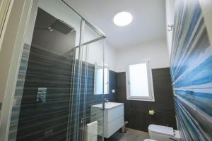 a bathroom with a glass shower and a sink at Artemisia Home in Olbia