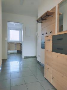 a kitchen with wooden cabinets and a tile floor at Apartment Waldblick - 77 qm, 2 Schlafzimmer, Balkon und Wi-Fi in Maulburg