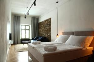 a bedroom with a large bed and a black chair at Welkam in Poprad