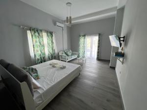 La Casa Sorento في فيكتوريا: غرفة نوم مع سرير وغرفة معيشة مع أريكة