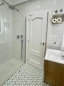 a bathroom with a shower and a sink and a door at La Parada de León in León