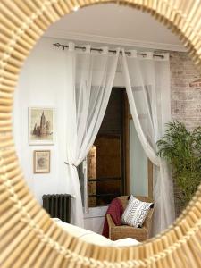 a mirror reflecting a room with a chair and a window at La Parada de León in León