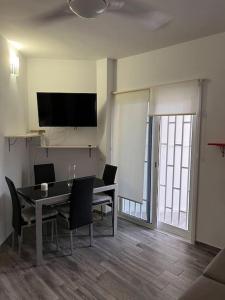 a dining room with a table and chairs and a television at Cozy apartment Costa Adeje in Adeje