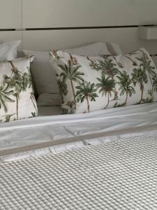 a bed with two pillows with palm trees on it at Cozy apartment Costa Adeje in Adeje
