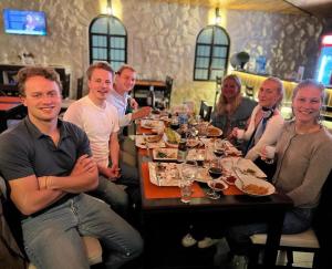 a group of people sitting around a table in a restaurant at Mount Nebo Hotel & Restaurant Madaba City Center in Madaba