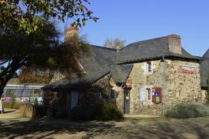 an old stone building with a sign on it at Les Roulottes & Cottages du Moulin in Chenillé-Changé