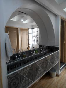 baño con 2 lavabos y espejo grande en Hostal Casa Pajaritos en Taxco de Alarcón