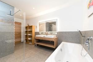 een badkamer met een bad, een wastafel en een douche bij Bel`Laret in Samnaun